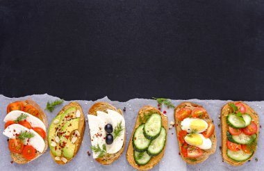 Taze sandviç sebze, yeşillik ve peynir, bir satırda düzenlenen ile karanlık ekmek üzerinde pirinç kağıt üzerinde hizmet ve siyah kopya alanı ile yukarıdan izlendi