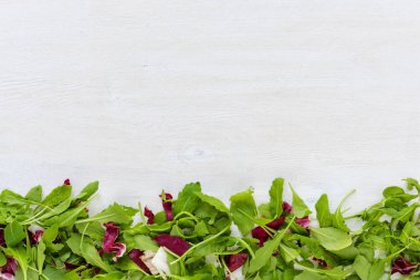 Yeşil ve kırmızı, yukarıdan izlendi Beyaz hindiba, yenilebilir bitki yaprakları ahşap masa yüzeyi kopya alanı ile boyalı. Mutfak malzemeleri, tarifi arka plan kavramı