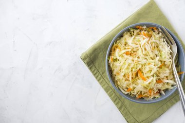 Çatal ve peçete tarafında lezzetli lahana turşusu ayakta kaseyle white'nın görüntüsünü yukarıda yüzeyi sıva