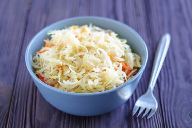 Beyaz bez ve kereste masa üzerinde yalan çatal ile nefis lahana turşusu kase parça