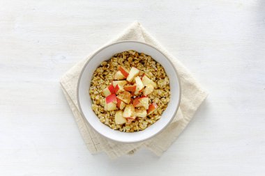 Yulaf ezmesi kase beyaz tablo karşı apple ile düz yatıyordu görünümü