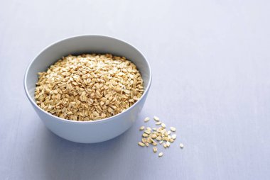 Gri seramik tabak bir gölge ile gri arka plan üzerinde kuru yulaf ezmesi görüntülendi closeup kopya alanı ile yüksek açıdan içinde