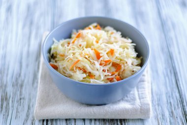 Seramik kase lezzetli fermente lahana peçete ahşap masa üzerinde duran