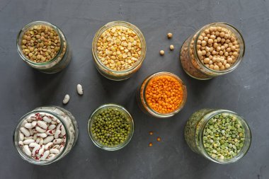 Mercimek ve bakliyat depolama görünümü yukarıdan aşağıya, vejetaryen mutfağı için sağlıklı maddeler için açık kavanozların mutfak içinde öldü