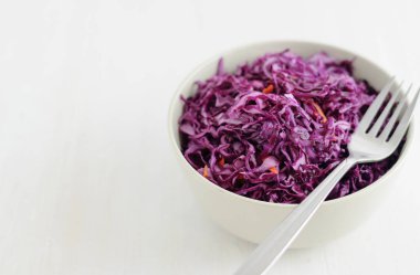 Seramik kase lezzetli mor fermente lahana beyaz arka plan üzerinde tam yatan çatal atış yukarıdan