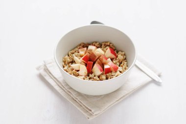 Beyaz seramik tabak yulaf ezmesi elma adet, kopya alanı beyaz zemin üzerine kaşıkla katlanmış havlu peçete üzerinde hizmet