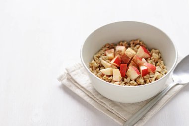 Beyaz seramik tabak yulaf ezmesi elma adet, kopya alanı beyaz zemin üzerine kaşıkla katlanmış havlu peçete üzerinde hizmet