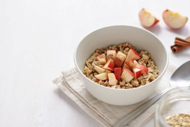 Beyaz seramik tabak yulaf ezmesi elma adet, hizmet üzerinde kopya alanı ile beyaz arka plan üzerinde katlanmış havlu peçete ile