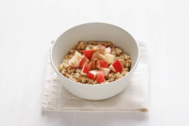 Beyaz seramik tabak yulaf ezmesi elma adet, hizmet üzerinde kopya alanı ile beyaz arka plan üzerinde katlanmış havlu peçete ile