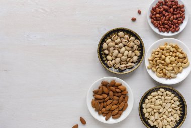 Kopya alanı ile dokulu beyaz üzerine yukarıdan izlendi bireysel kase taze fındık çeşitli çeşitli kenarlığını köşe