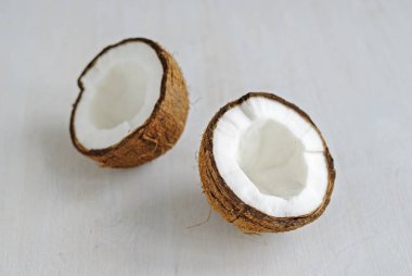 Bütün ve yarım, gri arka plan üzerinde oturan içinde kırık ve görüntülenen yakın çekim yüksek açıdan olgunlaşmış hindistancevizi