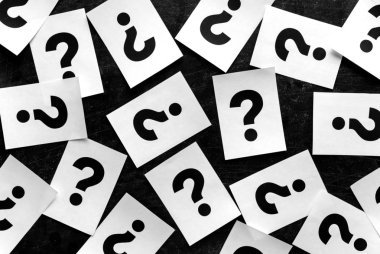 Kalın siyah soru işaretleri kağıt kartları rastgele kavramsal bir görüntüdeki siyah bir arka plan üzerinde dağınık.