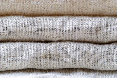 Düzgünce birbiri içinde tam çerçeve arka plan yakından yığılmış bir nötr gölgede keten dokuma katlanmış