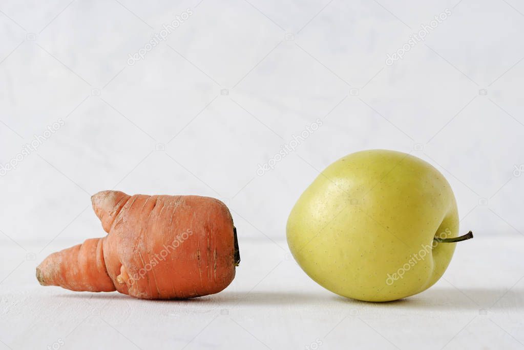 Misshapen golden apple and carrot on white