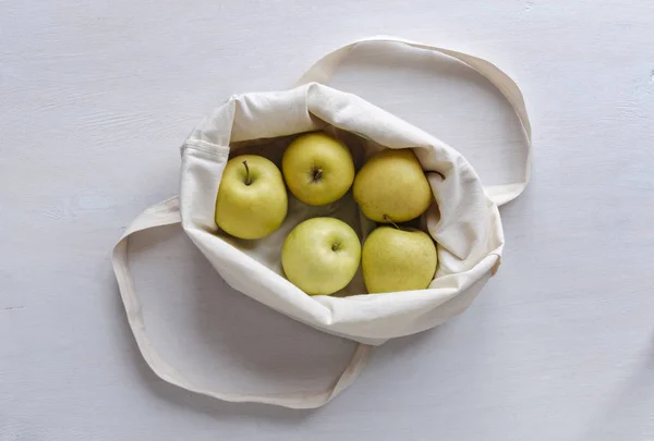 Cloth shopping bag with fresh golden apples