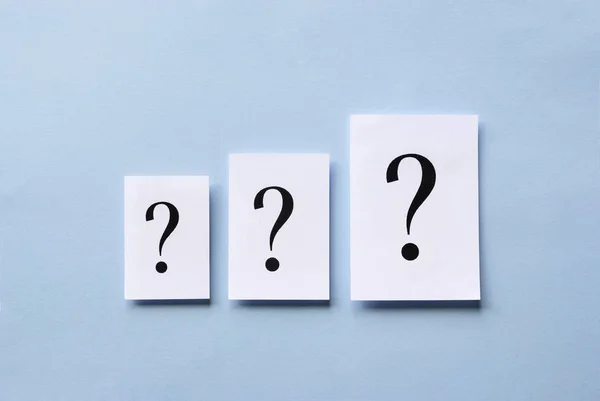 Three question marks of different size on card — Stock Photo, Image