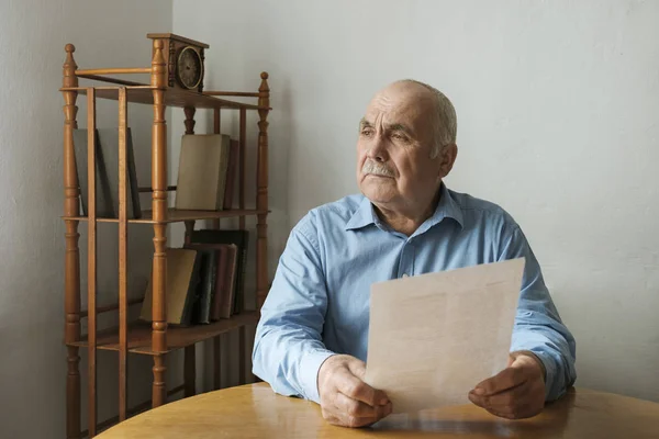 Man sitting contemplating a written document — Stock Photo, Image