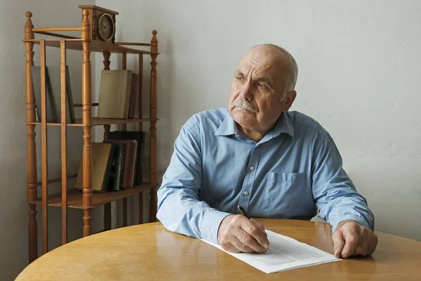 Old man writing notes or deciding to sign — Stock Photo, Image