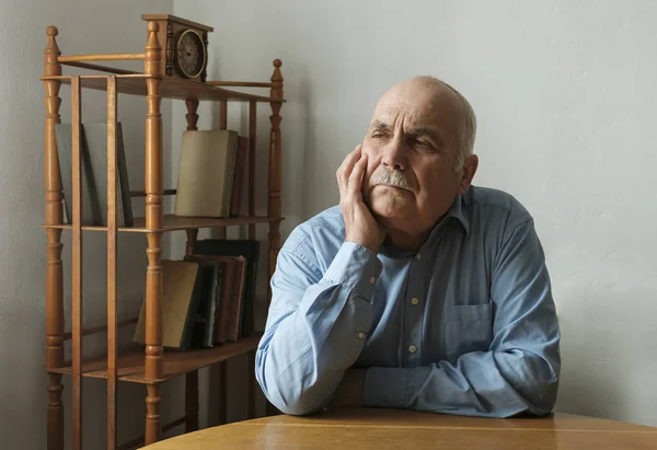 Senior man sitting deep in thought — Stock Photo, Image