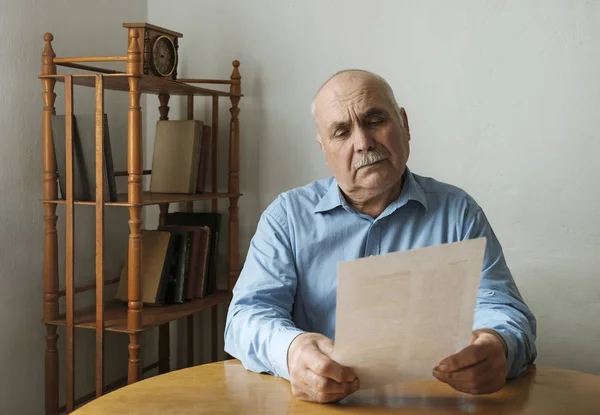 Old man reading a paper document or letter — Stock Photo, Image