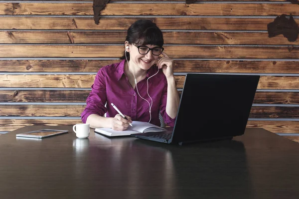 Mujer de negocios sonriente escuchando música en el trabajo — Foto de Stock