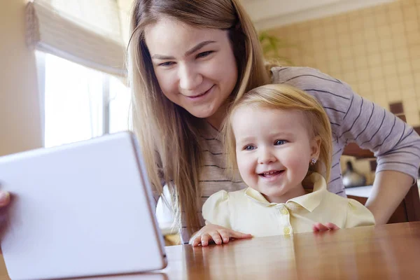 Young girl with her elder sister looking at tablet