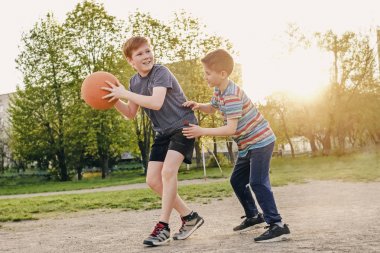 Basketbol oynayan iki mutlu genç çocuk