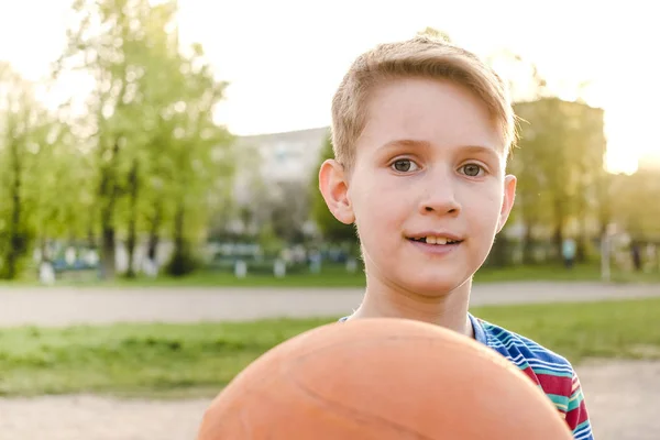 Gülümseyen dostu genç çocuk bir basketbol tutan — Stok fotoğraf