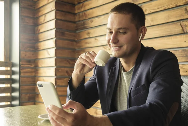 Hombre de negocios sonriendo mientras consulta un teléfono móvil — Foto de Stock
