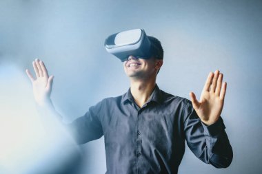 Sanal gerçeklik gözlüğü kullanan gülümseyen adam