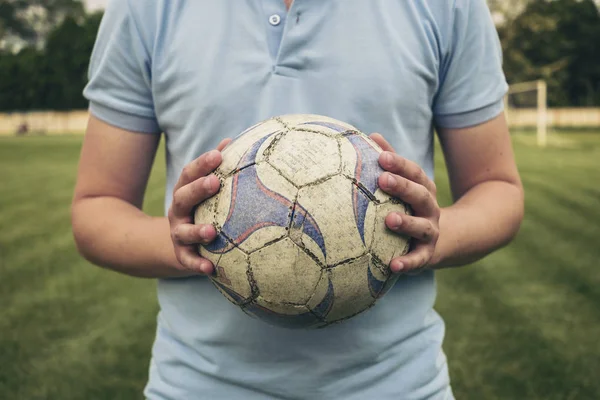 Giovane che tiene un pallone da calcio o da calcio — Foto Stock