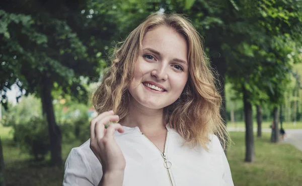 Saçlarıyla oynayan oldukça arkadaş canlısı genç kadın