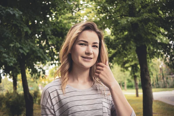 Lycklig vänlig ung blond kvinna i en Park — Stockfoto