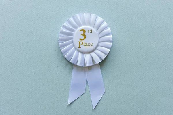 3rd Place white ribbon rosette on grey — Stock Photo, Image