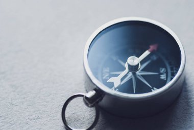 Gri arka planda küçük manyetik pusula