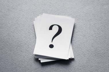 Question mark on paper cards on gray background. clipart