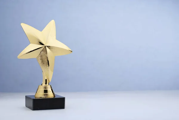 Star shaped golden trophy for rewarding in contest — Stock Photo, Image