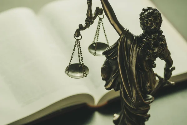 Figura de Justiça em pé sobre um livro de leis — Fotografia de Stock