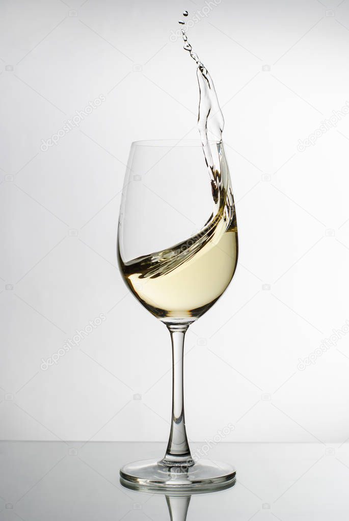 White wine splashing from an elegant wineglass