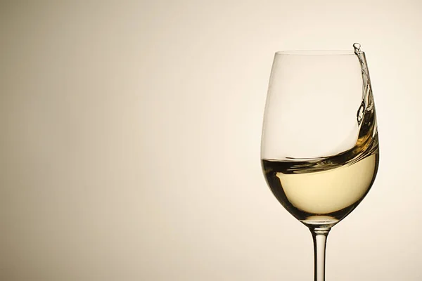 Suspended drops and splash of white wine in glass — Stock Photo, Image