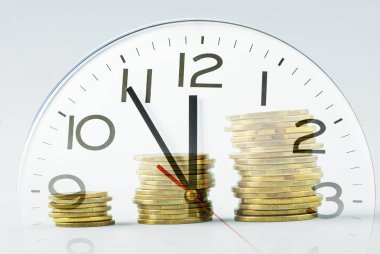 Bir saat kadranı üzerinde artan üç sikke yığını