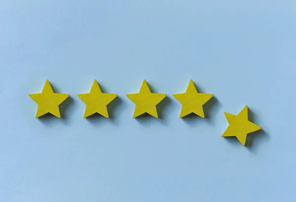 Line of five gold stars with one dropping away — Stock Photo, Image