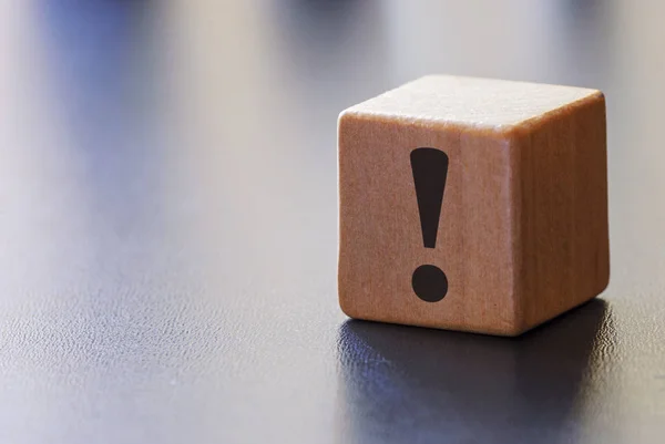 Warning exclamation mark on a wooden block — Stock Photo, Image