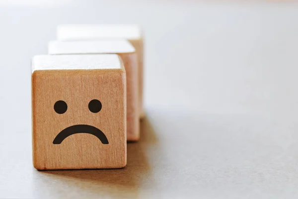 Wooden dice with sad emotion face