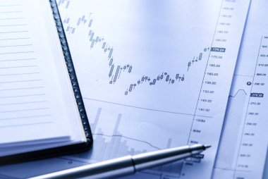 İş grafikleri ve kalem içeren bir günlük aç iş muhasebe veya istatistiksel analiz kavramını kapat