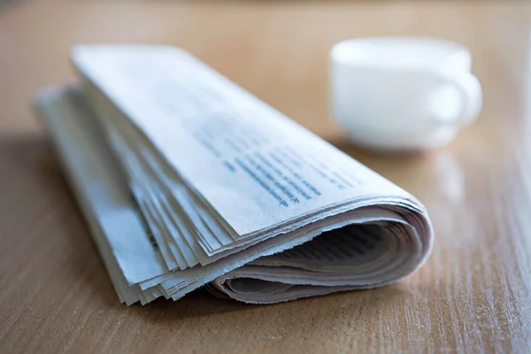 Folded Newspaper Wooden Table Cup Tea Coffee Background Focus Front — Stock Photo, Image