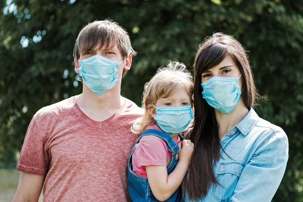 Familia Joven Con Hija Con Mascarillas Quirúrgicas Protectoras Durante Pandemia Fotos de stock libres de derechos