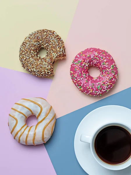 Color block flat lay with black coffee and delicious donuts in pastel colors