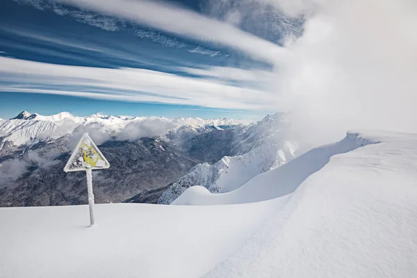 黄色危险标志 冬天的山 蓝天和雪暴风雪来背景 — 图库照片