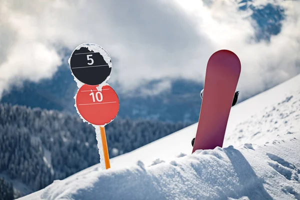 坡号标志和滑雪板直立站在滑雪坡边的雪 阳光明媚的冬日在山 — 图库照片